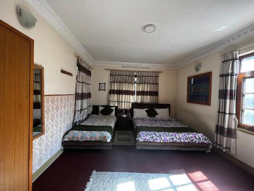 a bedroom with two beds and a window at Eco Resort in Dhulikhel