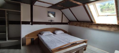 - un petit lit dans une chambre avec fenêtre dans l'établissement Domačija Markc, à Železniki