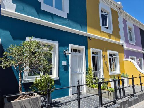 a colorful house on a street at De Waterkant Cottages in Cape Town