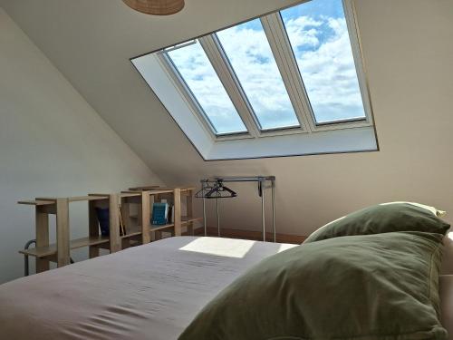 - une chambre avec un lit et une lucarne dans l'établissement Bel appartement neuf proche Disneyland et Paris- A proximité de la gare de Meaux, à Villenoy