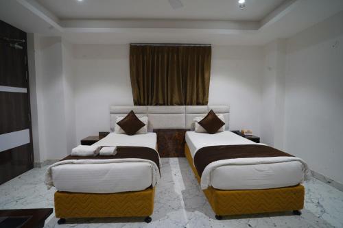 a bedroom with two beds and a window at Royal Bliss in Patna