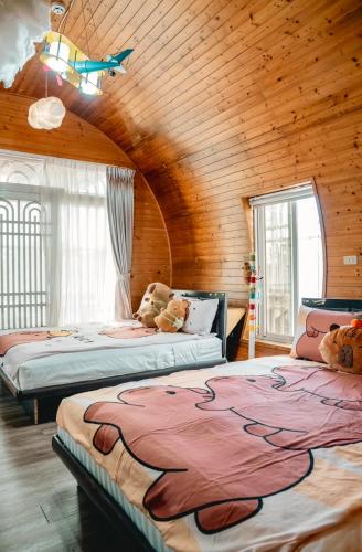 a bedroom with two beds in a wooden room at 海角42號三館包棟民宿-寵物友善 in Hengchun South Gate