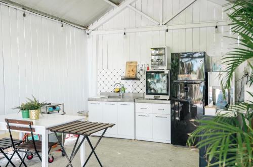 a kitchen with a black refrigerator and white cabinets at 海角42號三館包棟民宿-寵物友善 in Hengchun