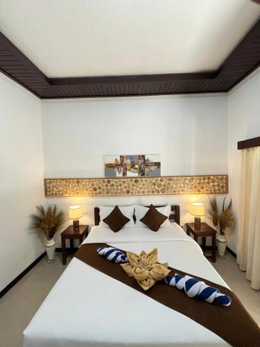 a bedroom with a large white bed and two tables at Penida Dream Homestay and hostel in Nusa Penida