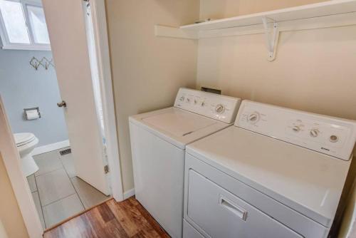 una lavatrice e asciugatrice bianche in un piccolo bagno di CO Traveler's Value Parks Sunsets CO Perfect a Colorado Springs