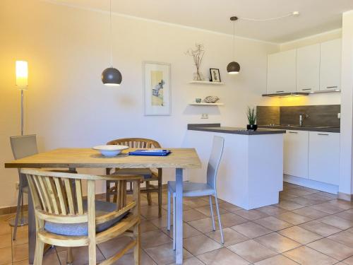 - une cuisine et une salle à manger avec une table et des chaises dans l'établissement Residenz am Strand, Whg 238, à Zingst