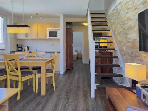 eine Küche und ein Esszimmer mit einem Tisch und einer Treppe in der Unterkunft Residenz am Strand, Whg 355 in Zingst