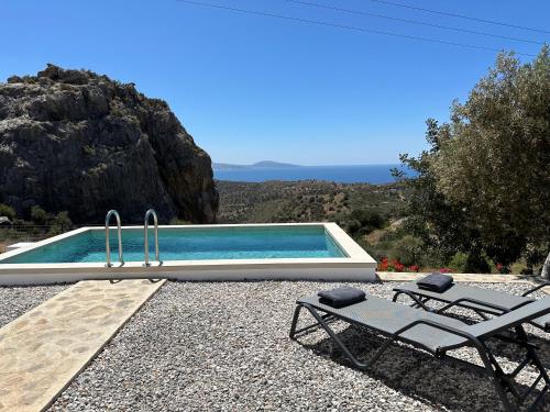 einen Pool mit 2 Stühlen und einem Tisch in der Unterkunft Vrachos Luxury Home 3, private pool! in Agia Galini