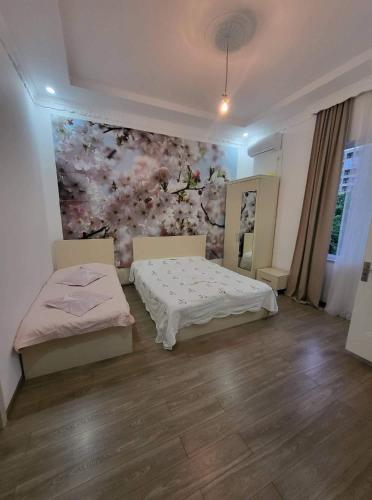 a bedroom with two beds and a flower wall at Kobuleti 327 a in Kobuleti