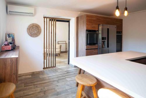 Il comprend une cuisine avec un comptoir blanc et du parquet. dans l'établissement NOUVEAUTE ! La Maison de la plage - tout confort avec jardin, à Propriano