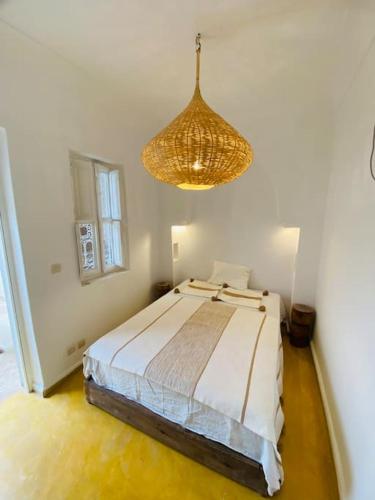 - une chambre avec un lit et un lustre dans l'établissement New private Riad Fiora, à Marrakech