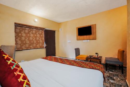 a hotel room with a bed and a tv at Nature Valley View Resort Mashobra !! Luxury Choice !! gaming zone !! open terrace !! Big Parking in Shimla