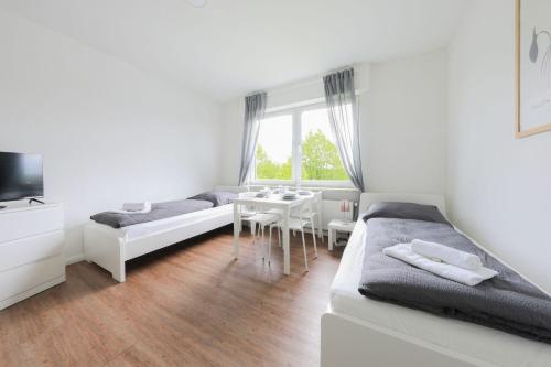 a white room with two beds and a table at Apartment in Schwerte in Schwerte