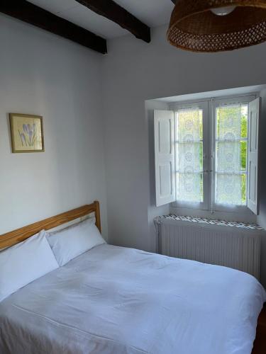 a bedroom with a white bed and a window at Posada -Meson la gándara 