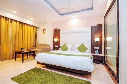 a hotel room with a large bed and a chair at Nature Valley View Resort Mashobra !! Luxury Choice !! gaming zone !! open terrace !! Big Parking in Shimla