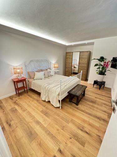 a bedroom with a large bed and a wooden floor at Victory Garda Relais - swimming pool-jacuzzi-bbq in Soiano del Lago