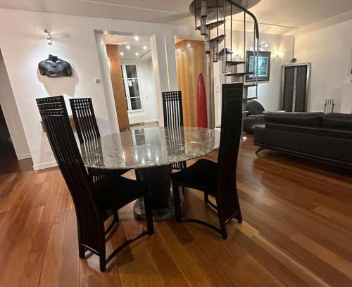 une table à manger et des chaises dans un salon dans l'établissement Magnifique appartement Paris proche Arc Triomphe, à Paris