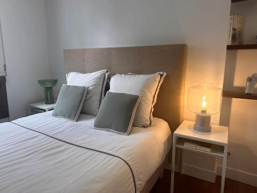 un lit avec deux oreillers et une lampe sur une table dans l'établissement Magnifique appartement Paris proche Arc Triomphe, à Paris