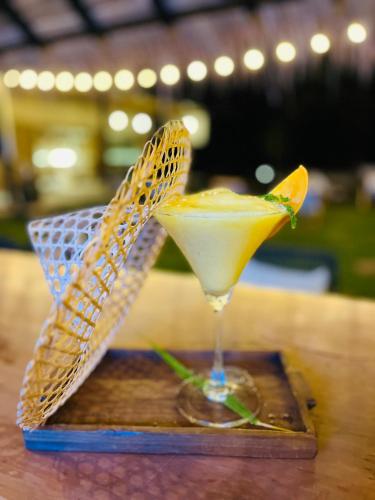 a drink sitting on top of a wooden table at Cape Pakarang Wow Wild Wellness Escapes in Khao Lak