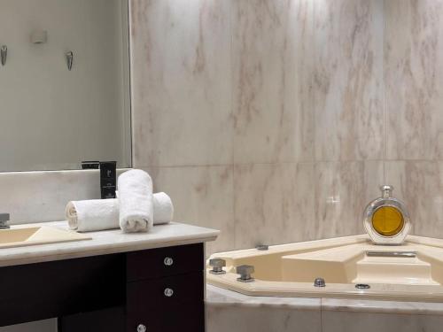 une salle de bain avec un lavabo, un miroir et une baignoire dans l'établissement Magnifique appartement Paris proche Arc Triomphe, à Paris