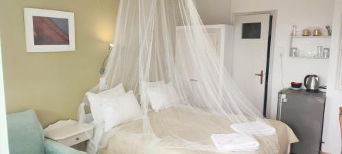 a bedroom with a bed with a mosquito net at Krinelos Rooms in Skala Eresou