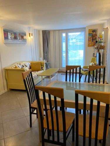 un salon avec une table, des chaises et un canapé dans l'établissement Doupassage, à La Châtelaine