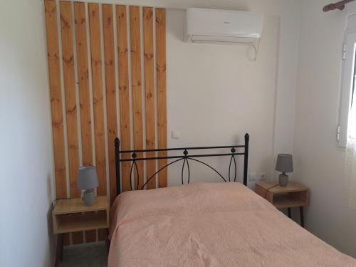 薩拉米斯的住宿－ILIAKTI RELAXING SEASIDE，一间卧室配有一张带木制床头板的床