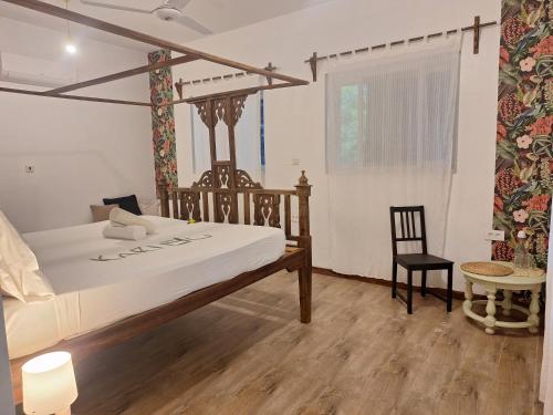 een slaapkamer met een bed, een tafel en een stoel bij Ocean Boho House in Jambiani