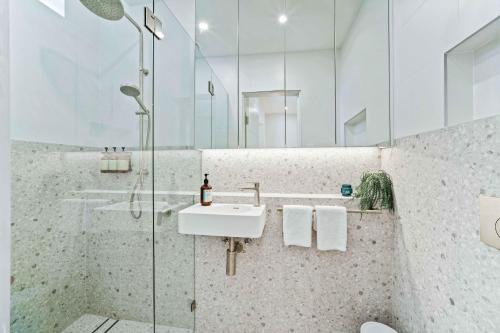 ein Bad mit einer Glasdusche und einem Waschbecken in der Unterkunft Phoenix at Palm View Collective in Sydney