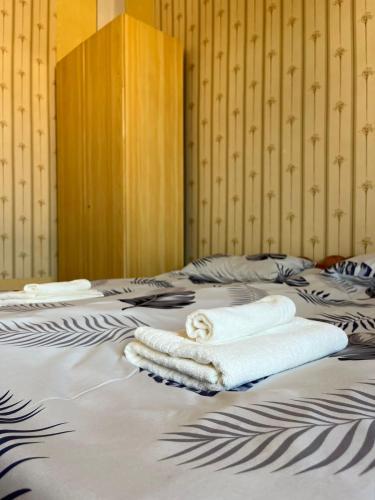 two towels are laying on a bed at Papoyan Guest House in Gyumri