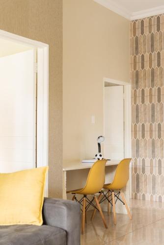 a living room with a couch and a table and chairs at Evans Village - Apartments & Spa in Johannesburg