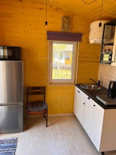 a kitchen with a refrigerator and a sink and a window at Katase Tiny House in Katase