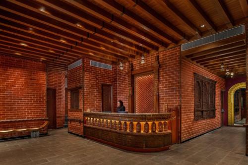 a person sitting at a bar in a brick building at Varnabas Museum Hotel in Kathmandu