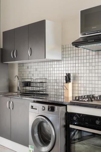 a kitchen with a washing machine and a stove at Evans Village - Apartments & Spa in Johannesburg
