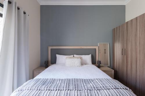 a bedroom with a large bed with white sheets at Evans Village - Apartments & Spa in Johannesburg