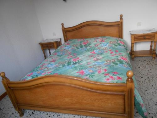 een houten bed met een groen dekbed met twee tafeltjes bij bouton d or in La Bresse