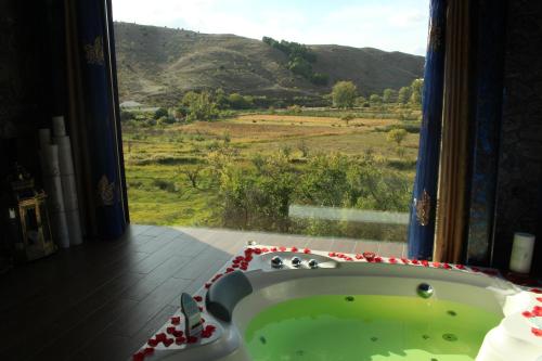 a bathroom with a tub with a view of a field at Suite Rural Carenas in Carenas