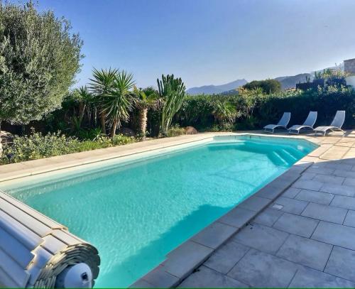 - une piscine dans une arrière-cour entourée de chaises dans l'établissement Casa U Maelou, à Lumio