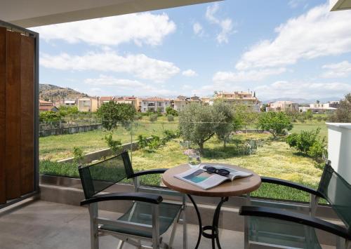 a balcony with a table and chairs and a large window at ENARIA in Nafplio