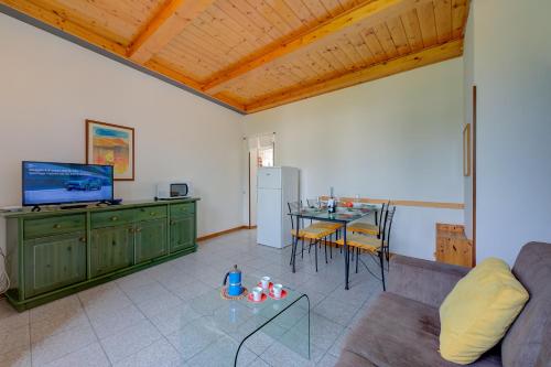 un soggiorno con divano e tavolo con TV di Al Peverì - Family Friendly - Happy Rentals a Toscolano Maderno