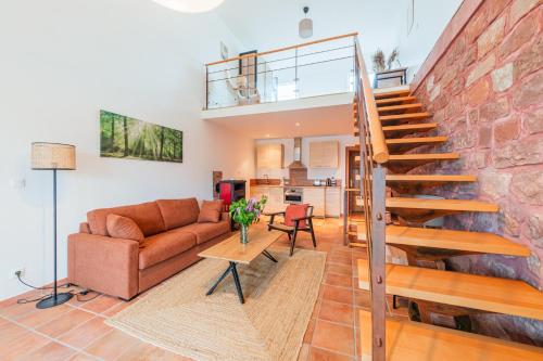 a living room with a staircase and a brick wall at Le Cerisier - Bel Appt pour 4 personnes in Puberg