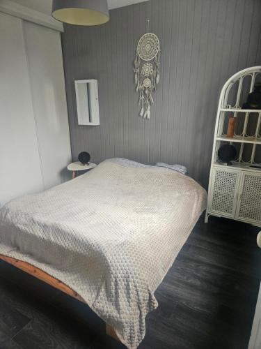 - une chambre avec un lit et une couverture blanche dans l'établissement Appart T2 avec cour, à Tours