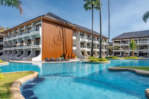 a swimming pool in front of a resort at Amora Beach Resort Phuket - SHA Extra Plus in Bang Tao Beach