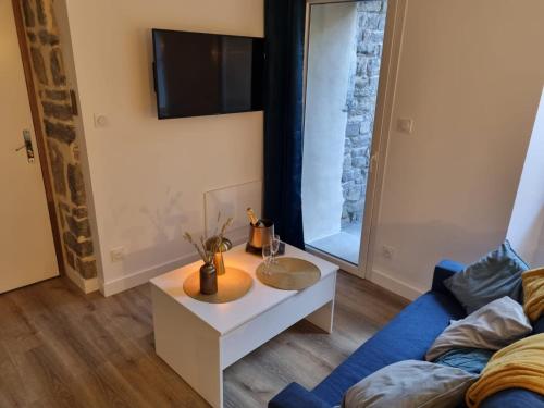 un salon avec une table et un canapé dans l'établissement Lhôtel de la Poule et du Renard Appartement avec Balnéo terrasse dans le centre du vieux Millau, à Millau