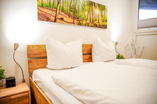 een slaapkamer met een bed met witte lakens en kussens bij FeWo Winterberg Panorama in Winterberg
