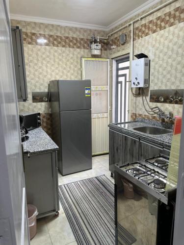 a kitchen with a black refrigerator and a sink at Quite apartment with positive vibes in New cairo