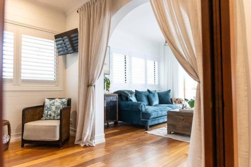 a living room with a blue couch and a chair at Coco's - in town {Ultima Collection} in Port Douglas