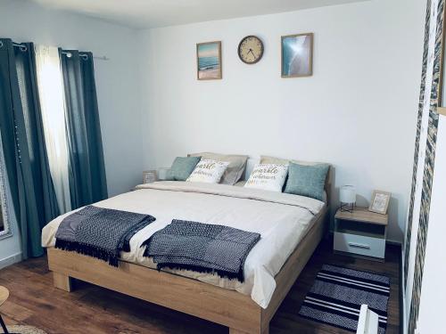 a bedroom with a bed and a clock on the wall at Kuća za odmor “Dida” in Stinica