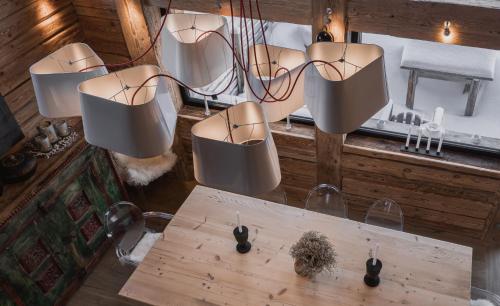 un groupe de feux suspendus au-dessus d'une table dans l'établissement Chalet Papillon - LES CHALETS COVAREL, à Val dʼIsère
