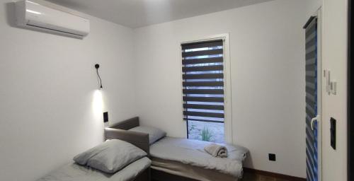 a white room with two beds and a window at ECO HOUSE in Szypliszki